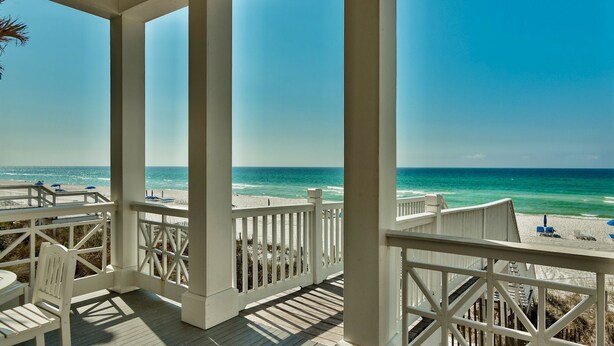A covered outdoor area with a view of the beach and ocean.
