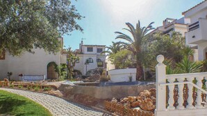 A courtyard with a fountain, cobblestone path, and white buildings with arched windows. - 3 bedroom gorgeous home in Gran Alacant (Gran Alacant)