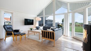 A spacious living room with a large window, a fireplace, and a television.