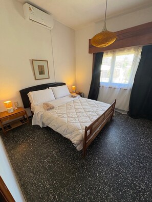 A bedroom with a bed, bedside tables, a lamp, a picture on the wall, and a window with curtains. - House Piriápolis Residential area beach 3 blocks (Piriápolis)
