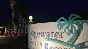 Letrero para Edgewater Beach Resort, con un logotipo de palmera.