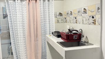 Een koffiezetapparaat/waterkoker, een eettafel