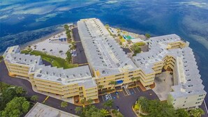 Un grand hôtel comprenant plusieurs bâtiments, un parking et un espace piscine.
