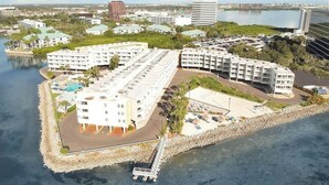 Un hôtel situé sur la côte, composé de plusieurs bâtiments, doté d’une piscine et d’un quai.