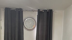 A room with a vanity, a mirror, and a clock on the wall. - Affordable luxury apartment (Stratford)