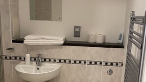 A small, clean bathroom with a sink, toilet, and towel rack. - Affordable luxury apartment (Stratford)
