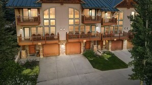 A multi-story house with a metal roof, large windows, and wooden balconies. - Spacious Mtn Retreat - 3 Minute Walk to Slopes + Hot Tub & Garage (Crested Butte)