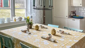 A dining area with a table set for four, a window with a view of greenery, and a kitchen area with cabinets and appliances. - Gorgeous home in Bodafors with kitchen (Bodafors)