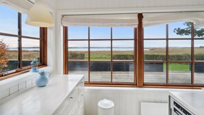 A kitchen with large windows, a white countertop, and a view of a grassy field. - 2 bedroom awesome home in Holbæk (Holbæk)