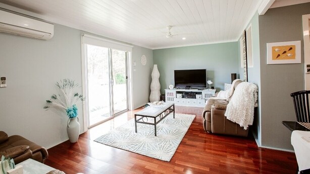 A living room with a sofa, a coffee table, a TV, and a fireplace.