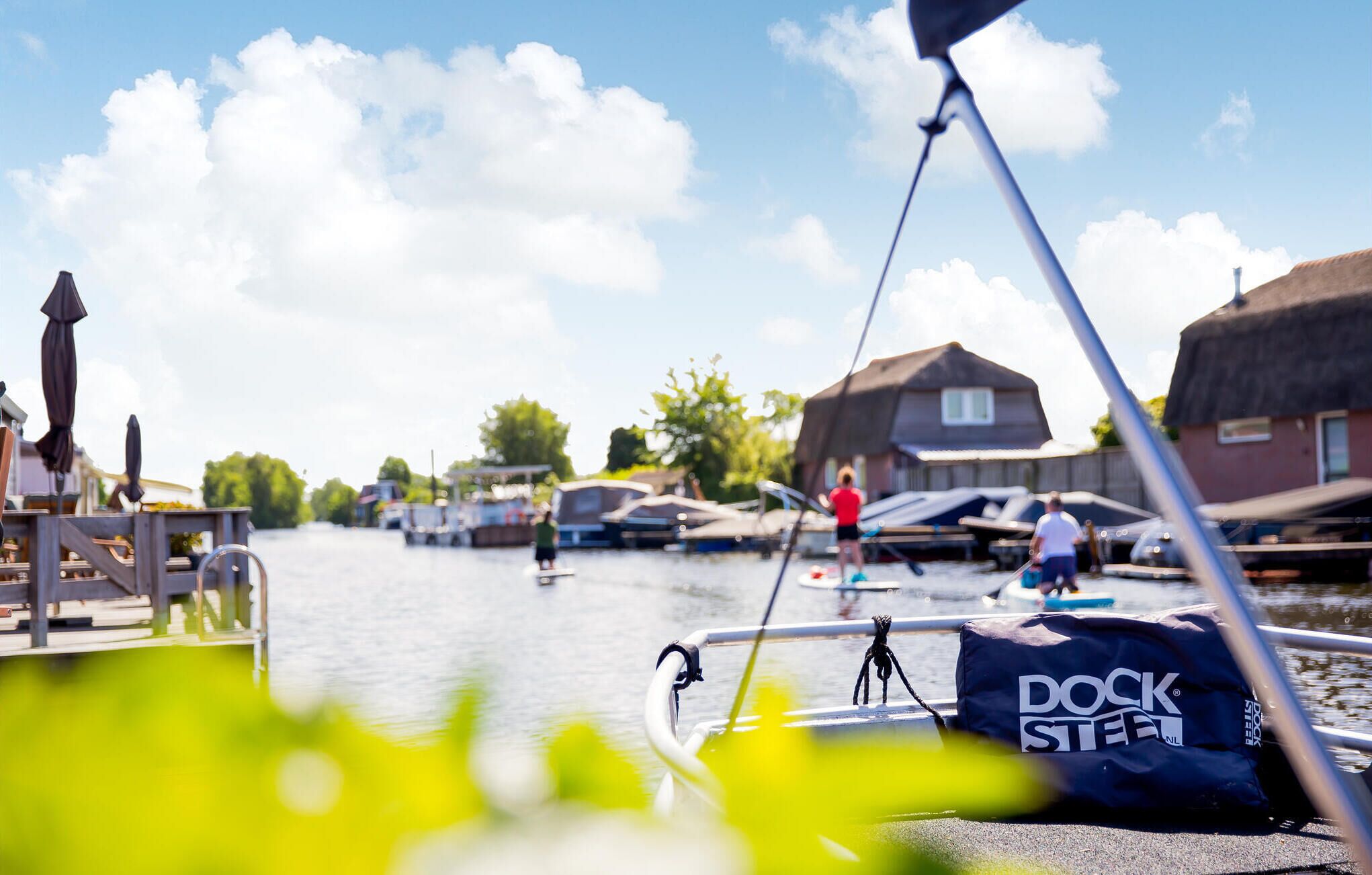 A boat docked at a pier with a 'DOCK STEEL' bag on the side.