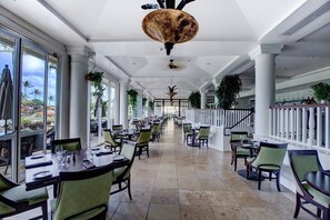 A spacious indoor dining area with high ceilings, large windows, and a central staircase. - Ocean View Room, Spectacular Beachfront Resort, 4 pools, Restaurants on site (Lihue)