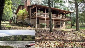 Un rustico chalet con balcone, immerso tra alberi e affacciato su un lago.