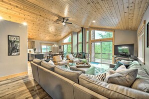 A spacious living room with a large sectional sofa, a dining area, and a kitchen in the background. - Bikes, Grill & Views: Luxe Truckee Cabin! (Truckee)
