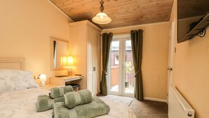 Une chambre d’hôtel avec un lit, un bureau, une chaise, une lampe et une vue sur l’extérieur.