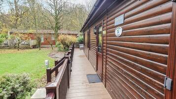 A wooden cabin with a wooden deck leading to a door marked "Thiklere."