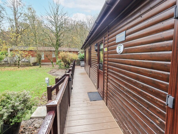A wooden cabin with a wooden deck leading to a door marked "Thiklere." - Damson Lodge (Windermere)