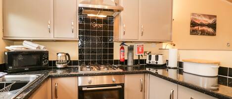 A modern kitchen with stainless steel appliances, a gas stove, and a built-in oven.