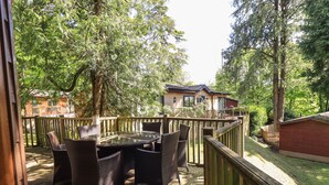 An outdoor deck with wicker furniture and a wooden deck floor. - Forest Pines Lodge (Windermere)