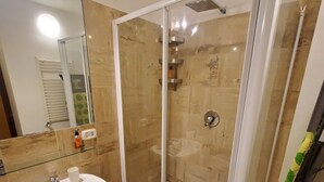 Ein Badezimmer mit Duschkabine, Waschbecken und Spiegel.