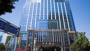 A modern hotel building with a prominent entrance, large windows, and signage indicating it is a hotel. - Ji Hotel (Suzhou)