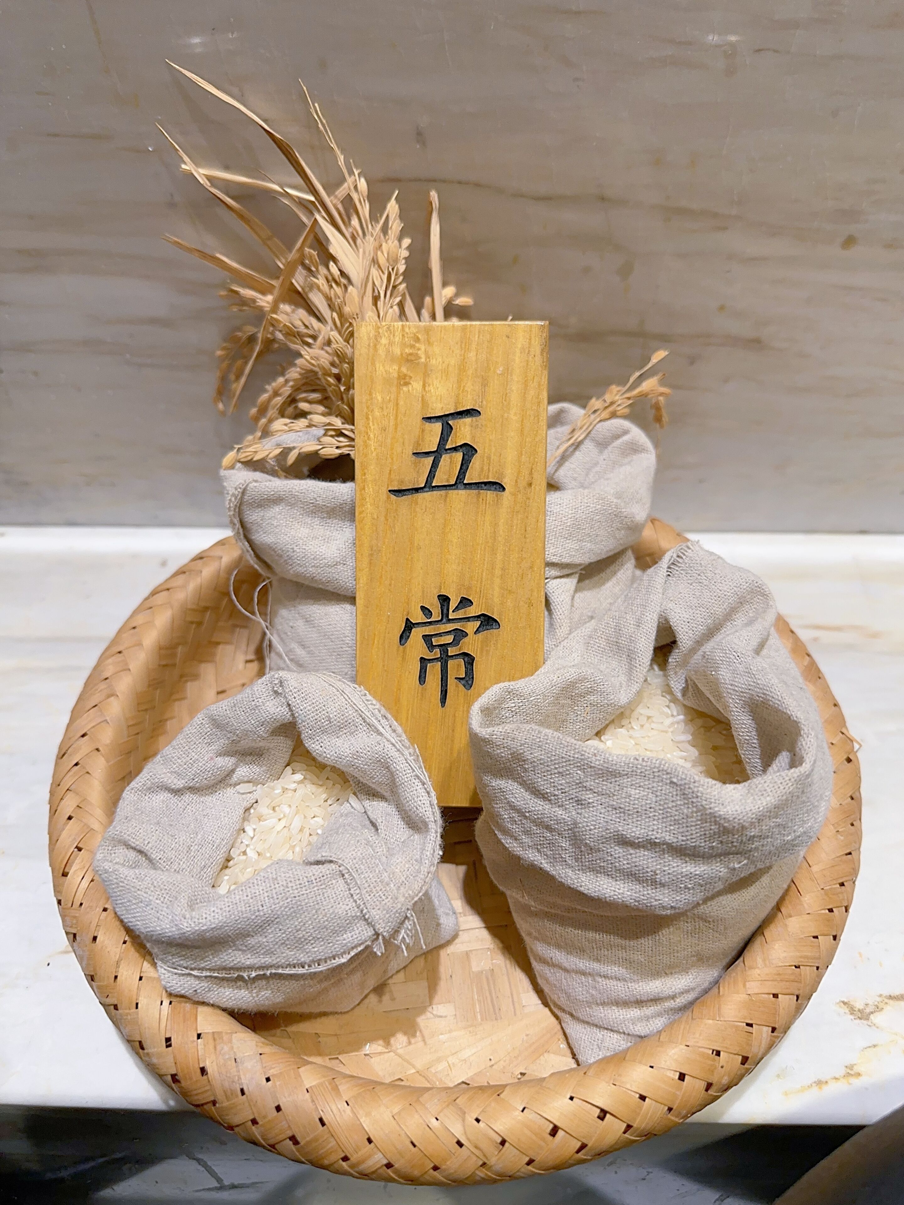A woven basket containing rice sacks and a wooden sign with Chinese characters.