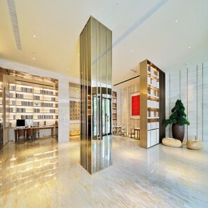 A modern library with bookshelves, a central glass partition, and a seating area. - Ji Hotel (Suzhou)