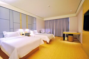 A hotel room with two beds, a desk, a chair, a small table, and a television. - Ji Hotel (Suzhou)