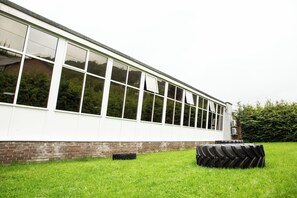 A building with large windows and a grassy area with tires.
