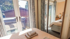 A bedroom with a bed, a window, and a view of the outside. - Robin View Lodge (Windermere)