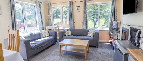 A cozy living room with two sofas, a coffee table, and a TV.