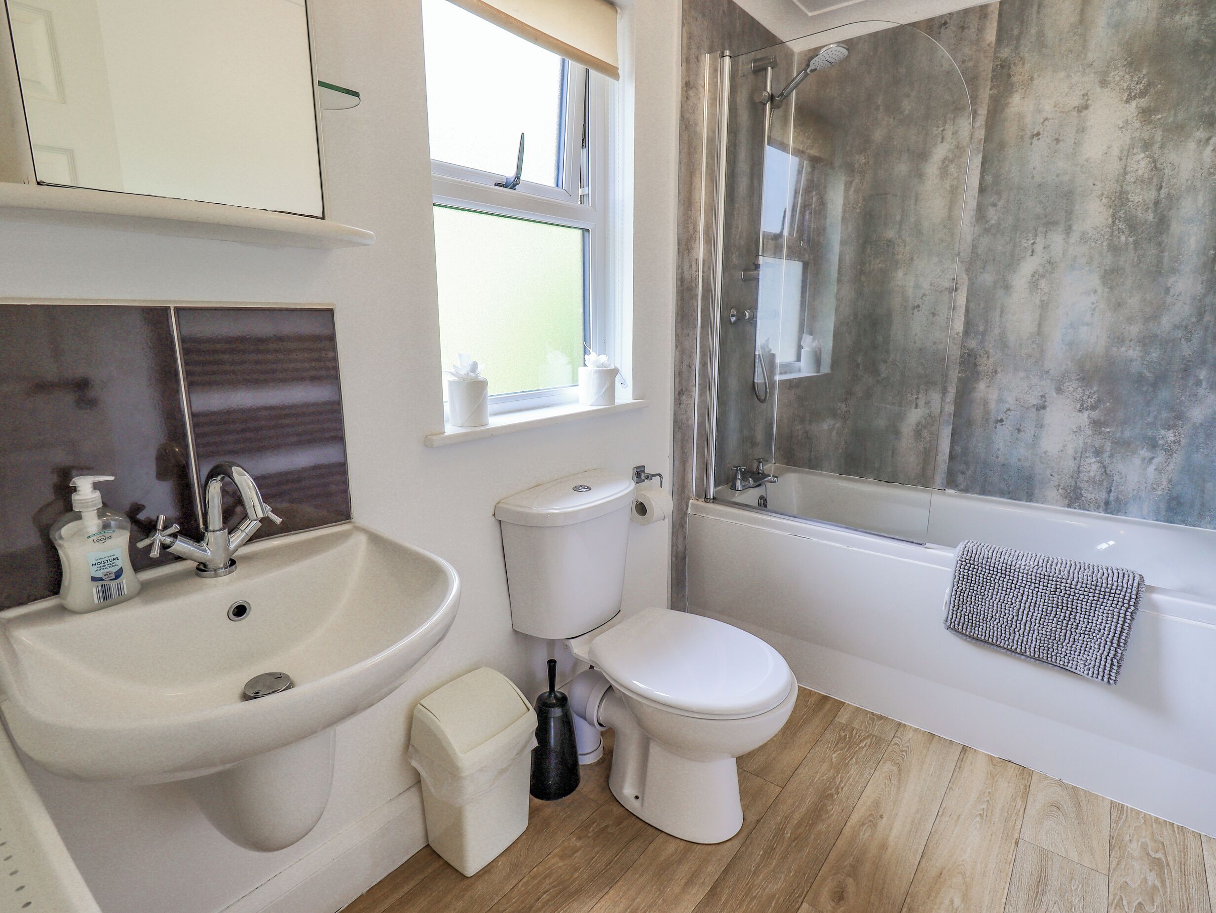 A bathroom with a sink, toilet, and shower.