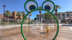 Ein Wasserspielplatz mit einer Frosch-Figur und einem gelben Ball.