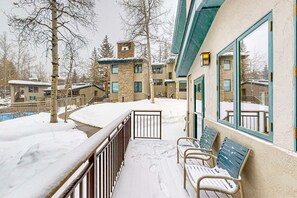 Enjoy the serene view from this hotel's balcony, featuring a cozy seating area with chairs and a table.