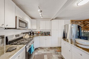 Enjoy cooking in this well-equipped kitchen with a stove, microwave, and refrigerator.
