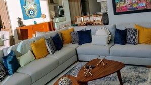 A modern living room with a grey sectional sofa, wooden coffee table, and a colorful rug. - Amazing Jewel Beach front Condo with great views (Bucerias/ Nuevo Vallarta)