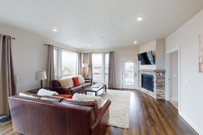 Relax in this stylish living room with a sofa, fireplace, and large windows.