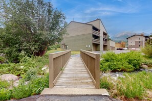 Stroll across the bridge to a serene retreat surrounded by lush greenery and a tranquil stream.