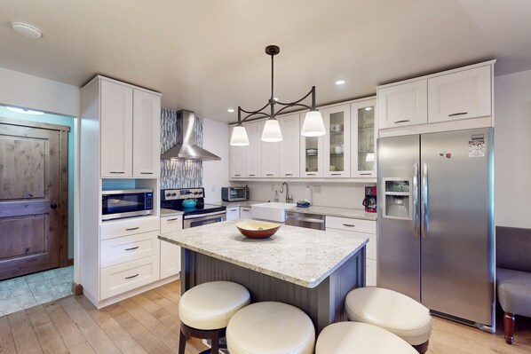 Enjoy cooking in this well-equipped kitchen with a central island, stainless steel appliances, and ample counter space.
