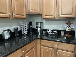 Enjoy a convenient coffee bar with a coffee maker, kettle, and mug display.