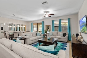 Relax in this spacious living room with a large coffee table, two sofas, and a dining area.