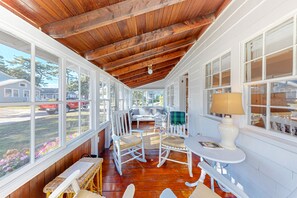 Relax on the covered porch with comfortable seating and large windows offering a view of the surrounding neighborhood.