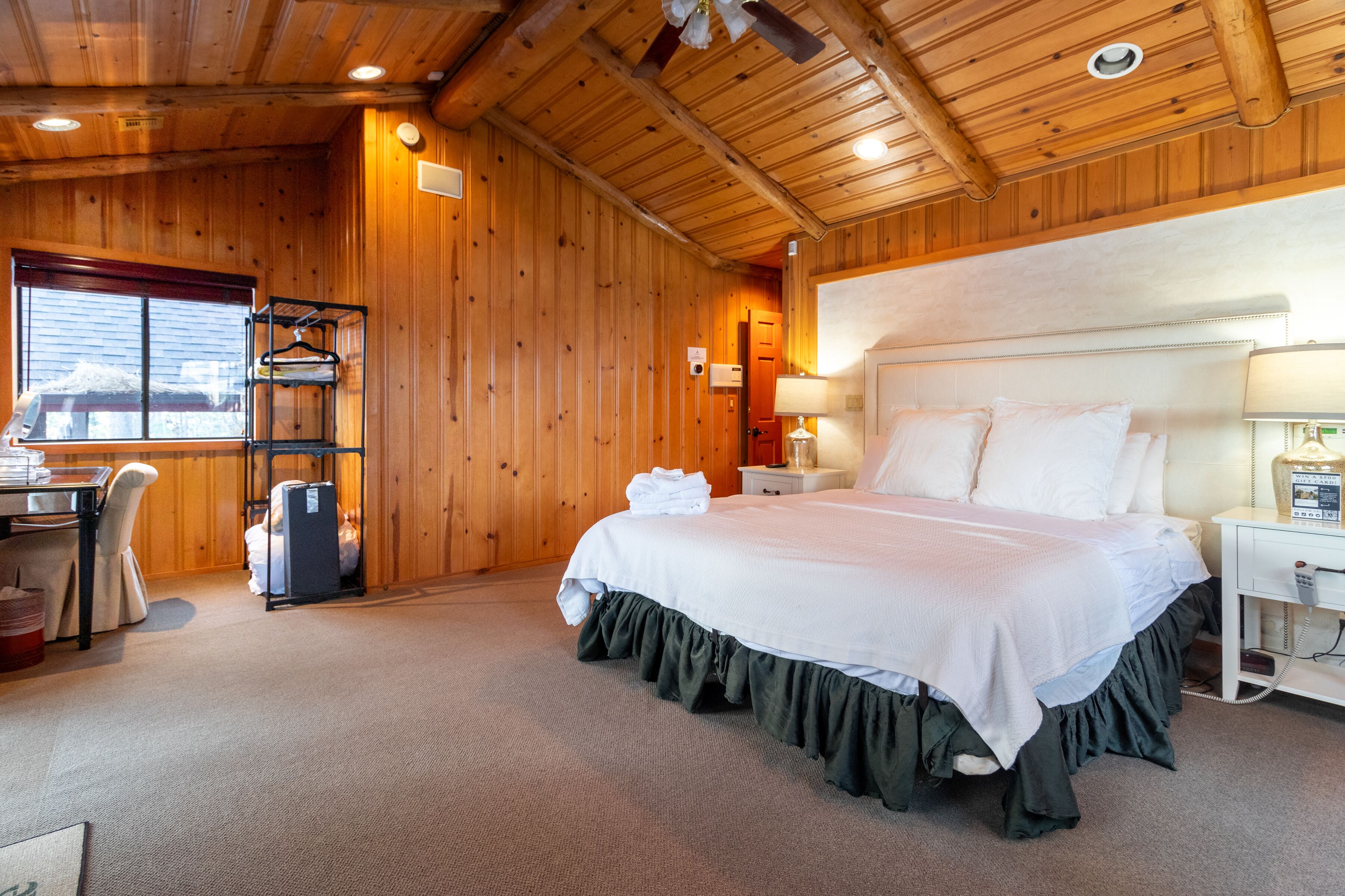 Una habitación con paneles de madera, una cama, un escritorio y una silla.
