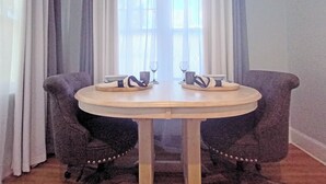 Een ronde tafel met twee stoelen, een wijnglas en een kopje op een dienblad.