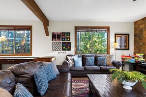 Ein Wohnzimmer mit braunem Ledersofa, einem Couchtisch und einer Topfpflanze.