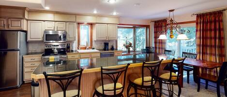 Enjoy cooking in this well-equipped kitchen with a large island, stainless steel appliances, and ample counter space.