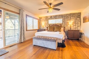 Ein Schlafzimmer mit einem großen Bett, einem Deckenventilator und Blick ins Freie.