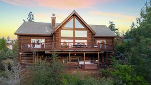 A log cabin with a large balcony and multiple windows.