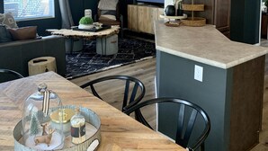 A modern kitchen with a wooden island, dark walls, and a large window. - Entire Home! Big Style, Big Views, Great Location! (Pine)