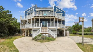 A two-story house with a balcony, a front porch, and a driveway.